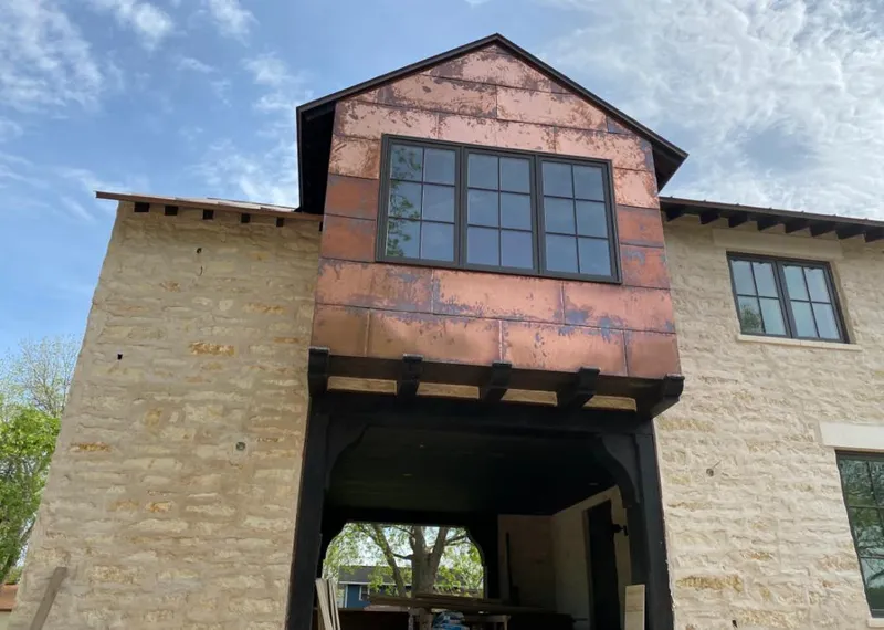 Copper metal panel facade on a stone building for Skylight Installation in Omak